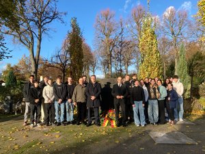 Bürgermeister Shaikh und Stadtverordnetenvorsteher von Sternheim stehen mit Schülerinnen und Schülern der HvK vor dem Ehrenmal