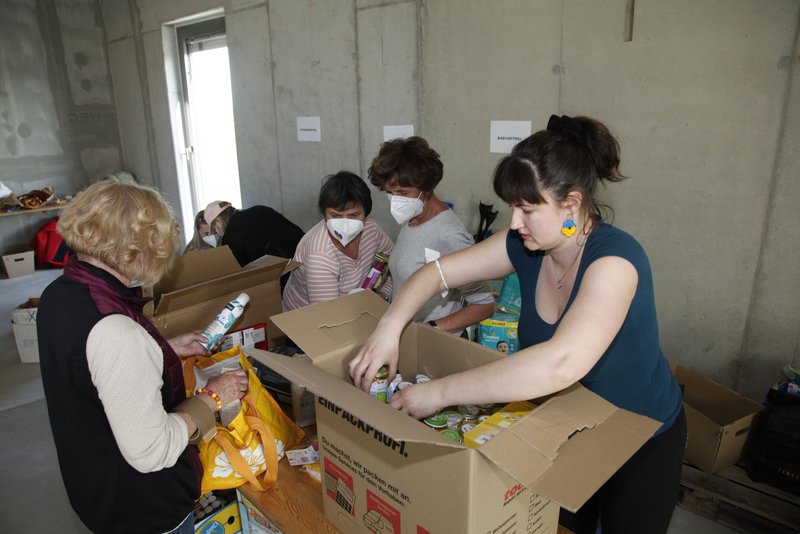 Natalija Stankiewicz (blaues T-Shirt) und drei Helferinnen verpacken Spenden in Umzugskisten.