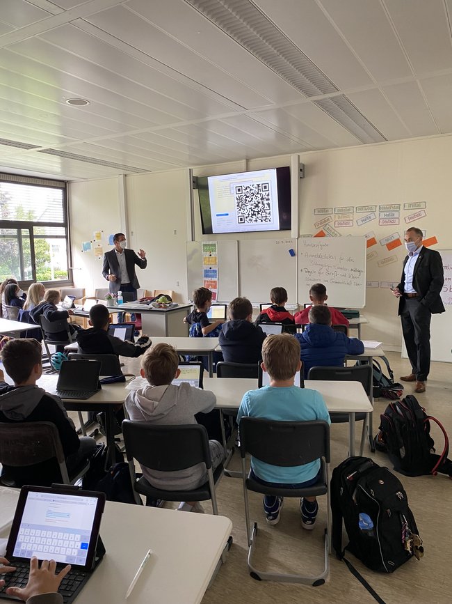 Der Schulleiter der Heinrich-von-Kleist Schule Marc Heimann (links) und Bürgermeister Adnan Shaikh besuchen eine 5. Klasse, die mit neuen Endgeräten ausgestattet wurde.