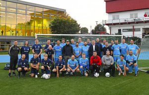 Die Mannschaften tragen mittelblaue und dunkelblaue Trikots und haben sich zum Gruppenfoto aufgestellt.