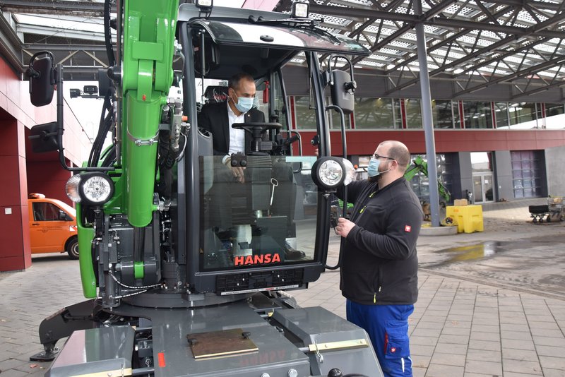 Bürgermeister Adnan Shaikh überreicht den Fahrzeugschlüssel für den neuen Mobilbagger an den neuen Nutzer.