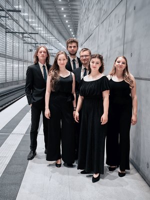 Das Ensemble voicemade in schwarzer Kleidung vor einer grauen Betonwand