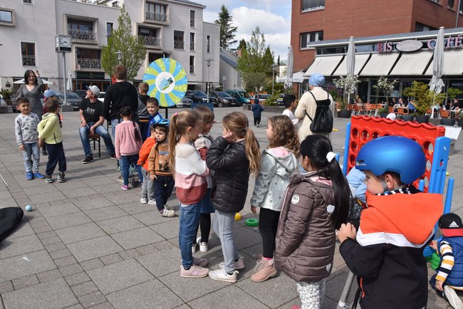 Viele Kinder stehen auf dem Rathausplatz Schlange und warten darauf, am Glücksrad drehen zu dürfen.