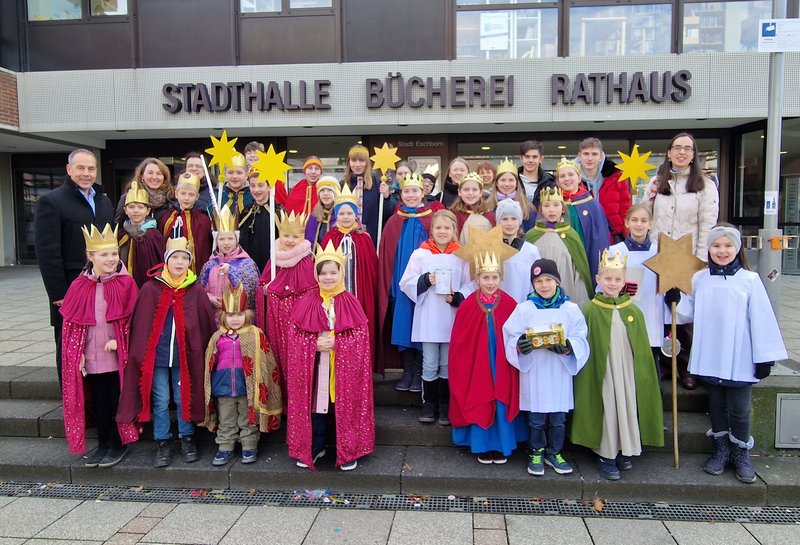Die Sternsinger stehen in bunten Kostümen vor dem Rathaus. Ganz links: Bürgermeister Shaikh