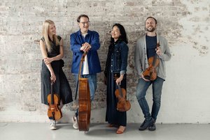 Das Doric String Quartet mit Instrumenten vor einer Betonwand