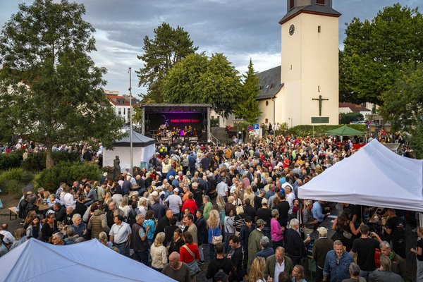 Der Eschenplatz ist voller Menschen. Im Hintergrund sieht stehen die Bühne und rechts die evangelische Kirche.