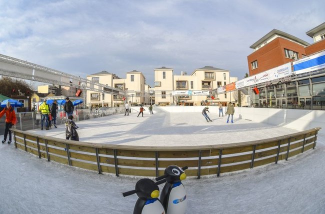 Kinder und Jugendliche auf der Eisbahn auf dem Rathausplatz.
