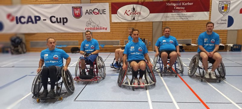 Sechs Männer, darunter Adnan Shaikh ganz links, sitzen in Sportrollstühlen. Sie tragen hellblaue Trikots.