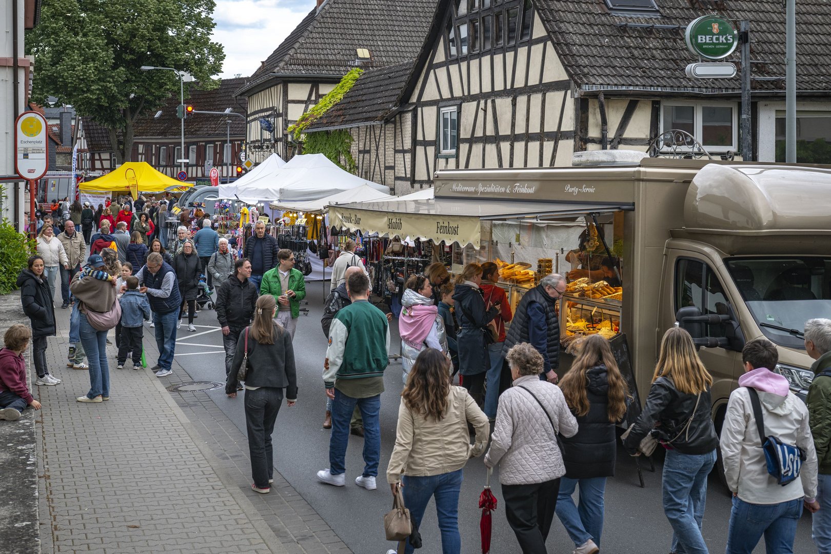 Viele Menschen vor den Essensständen in der Hauptstraße.
