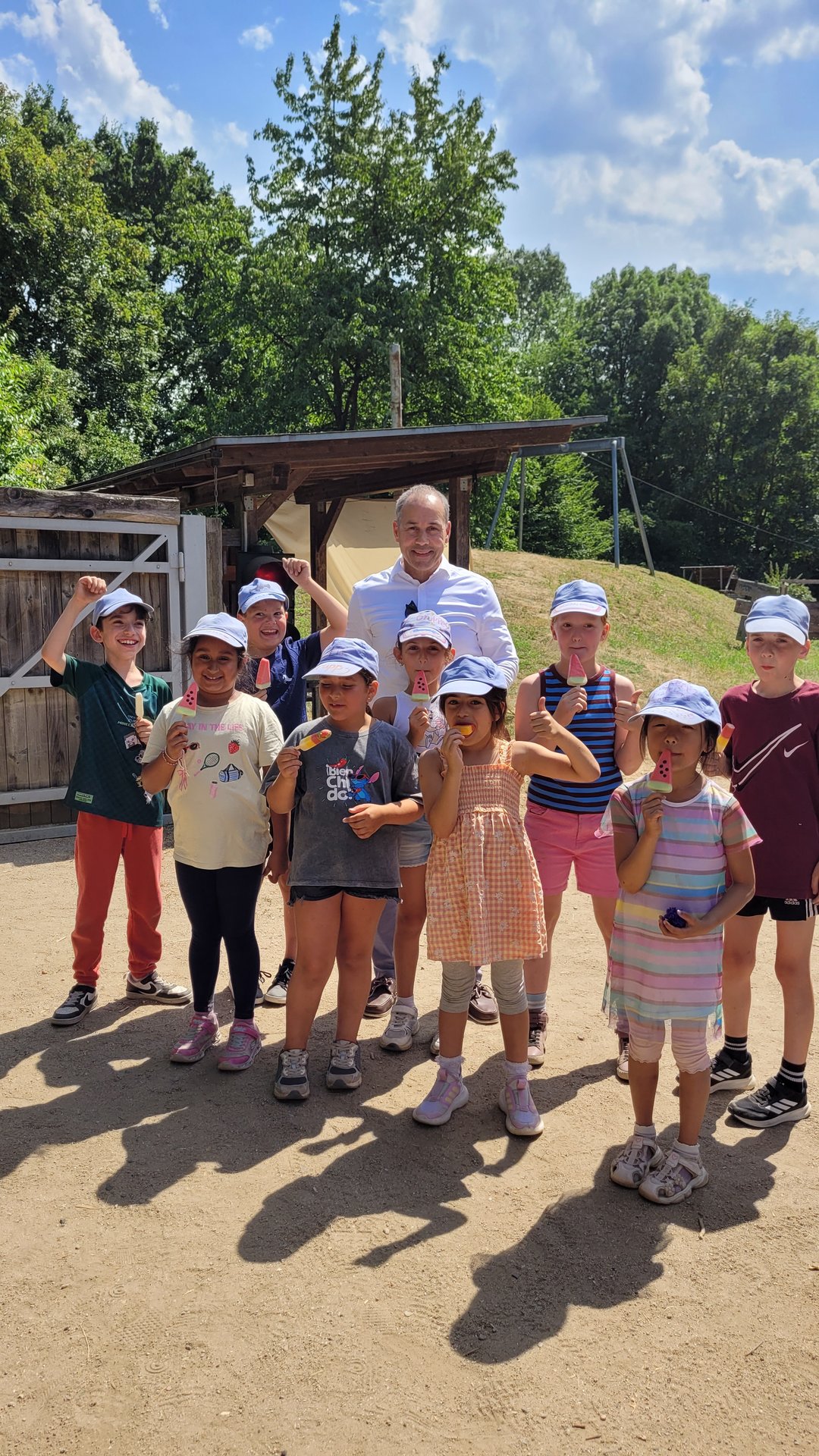 Bürgermeister Shaikh und eine Gruppe Kinder, alle halten ein Eis in der Hand