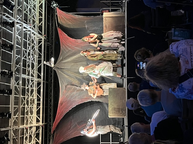 Fünf Schauspielerinnen udn Schauspieler auf der Bühne. Einer spielt Posaune, einer Gitarre.